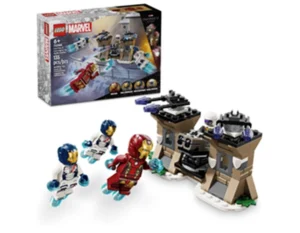 Imagem de um conjunto LEGO Marvel inspirado nos Vingadores. A cena inclui miniaturas do Homem de Ferro e três soldados da S.H.I.E.L.D. com mochilas a jato, voando em direção a uma base com duas torres. Há elementos tecnológicos e armas no cenário. Ao fundo, a caixa exibe uma ilustração da batalha. Indicado para maiores de 6 anos e contém 135 peças.